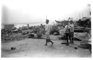 Some Ogoni inhabitants survey the impact of violence along the waterfront at Port Harcourt, 5th January 1994. Photograph by Sr. Majella McCarron. Maynooth University Ken Saro-Wiwa Archive.
