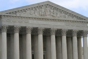 The front top of the white marble Supreme Court building is shown, with eight rows of columns and a top message that reads, "Equal Justice Under Law."