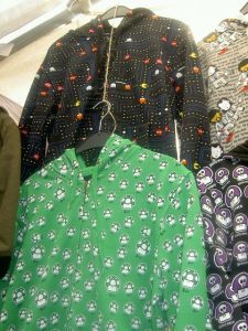 Picture of two hooded sweatshirts, one green and one black, with mushroom designs on both.