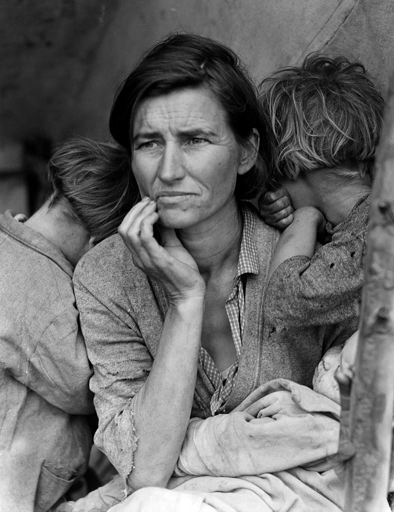 Migrant mother shelters children during the Great Depression