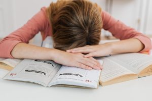 Teen asleep on books