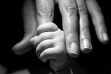 Image of baby grasping an adult hand