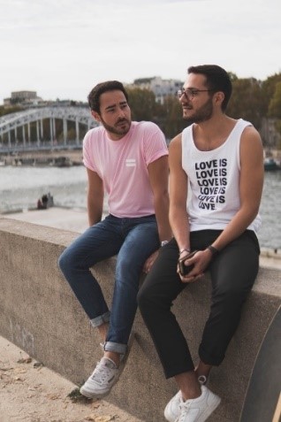 two men sitting atop a short wall