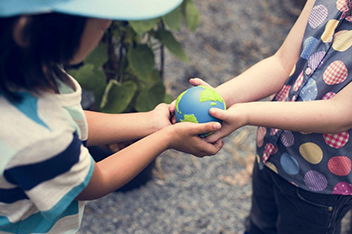 image of two children holing a small earth ball