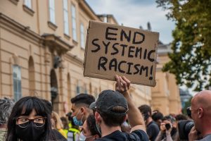 Protest sign says "end systemic racism"