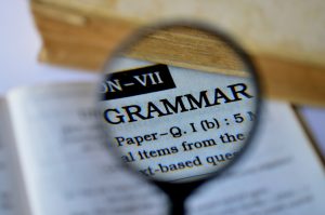 magnifying glass focuses on the word grammar in a book