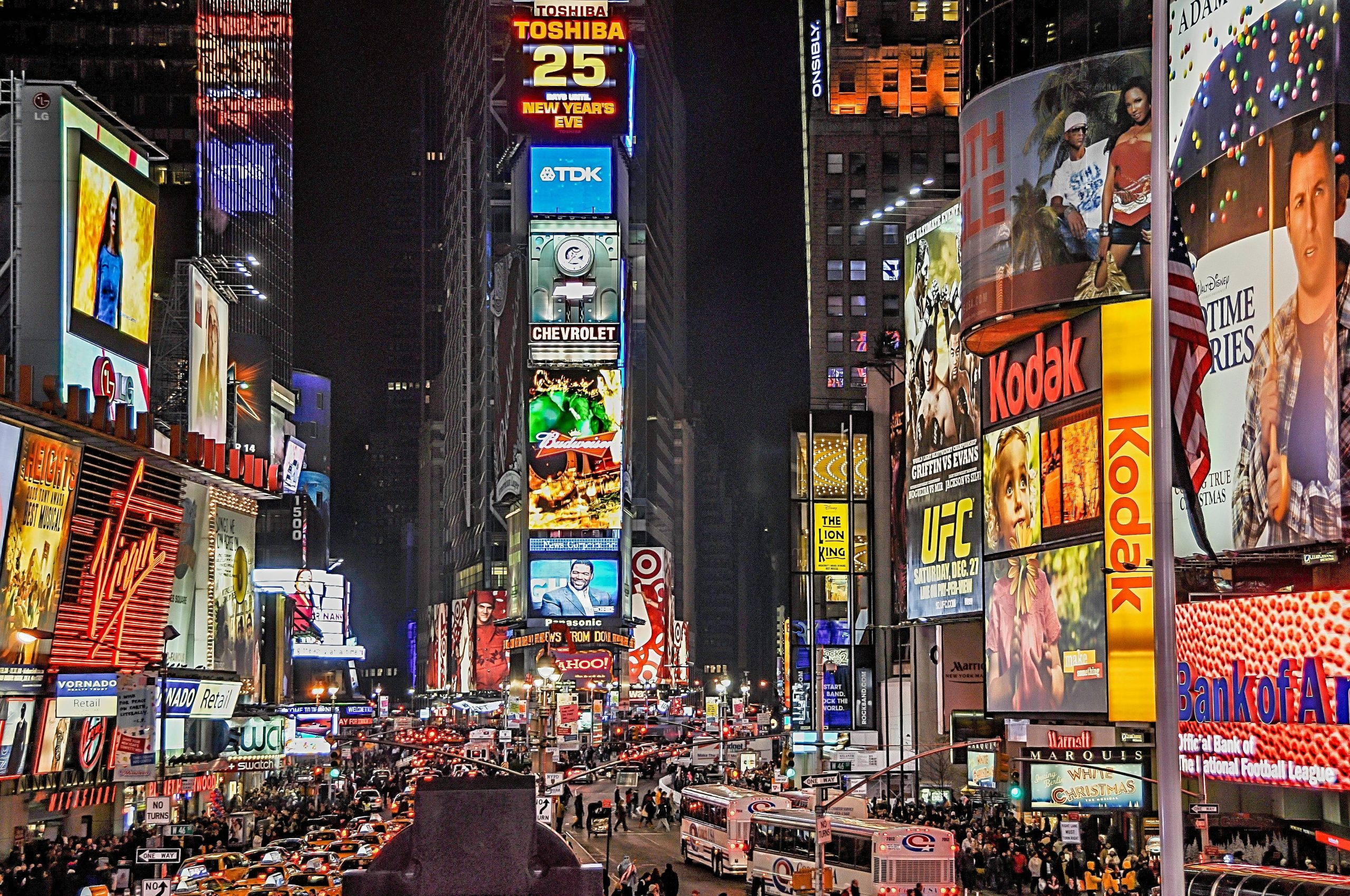 Times Square in New York City at night with ads brightly lit.