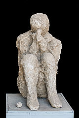 a plaster cast of a sitting individual