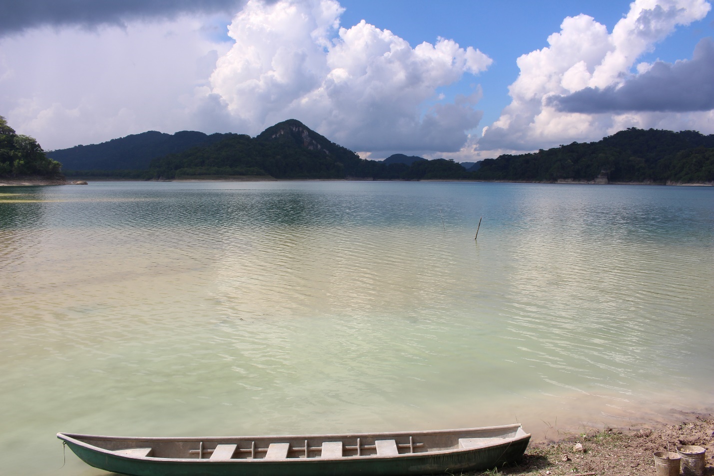 Boat in front of a lake surrounded by hills