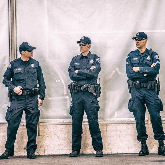 three men in uniform wearing glasses with guns