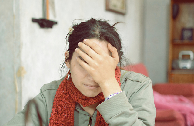 photo of woman with head in her hand