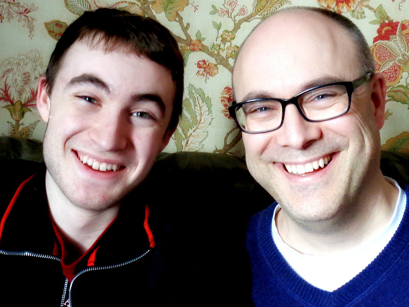 older male and younger male headshot smiling