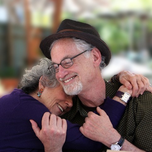 photo of an elderly couple hugging and smiling