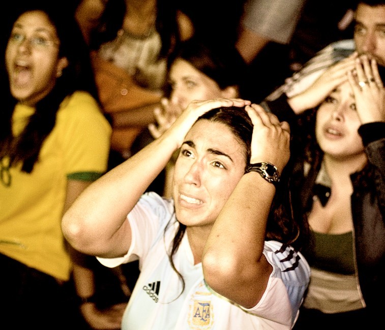 photo of sports fans holding their heads