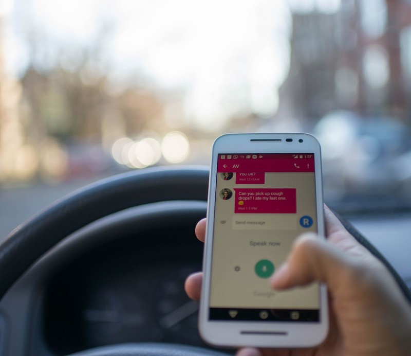 a photo of a person texting and driving