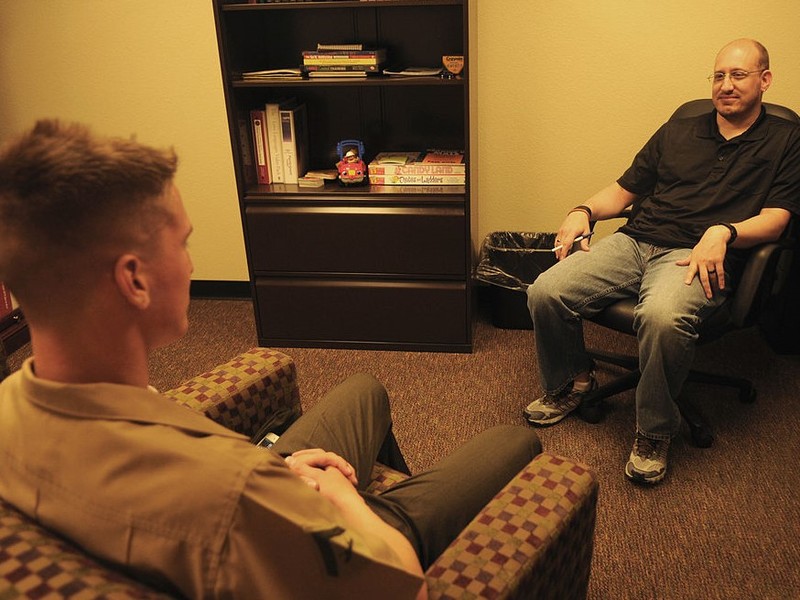 two men sitting in chairs smiling at eachother