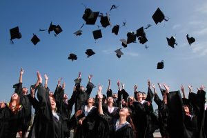 Photo of happy graduates throwing their caps in the air.