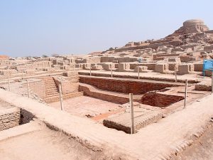 A photograph of the ruins of Mohenjo-Daro, with the Great Bath in the foreground and the granary mound in the background