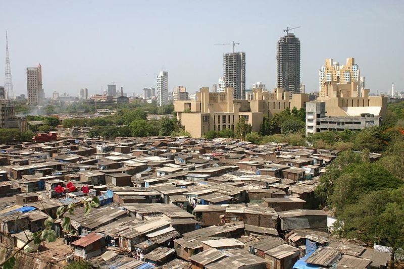 Slum in Mumbai India, with high rise buildings being constructed in the background