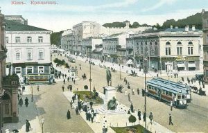 Postcard showing a painting of a street scene with a wide boulevard, classical white painted buildings and people and trams walking