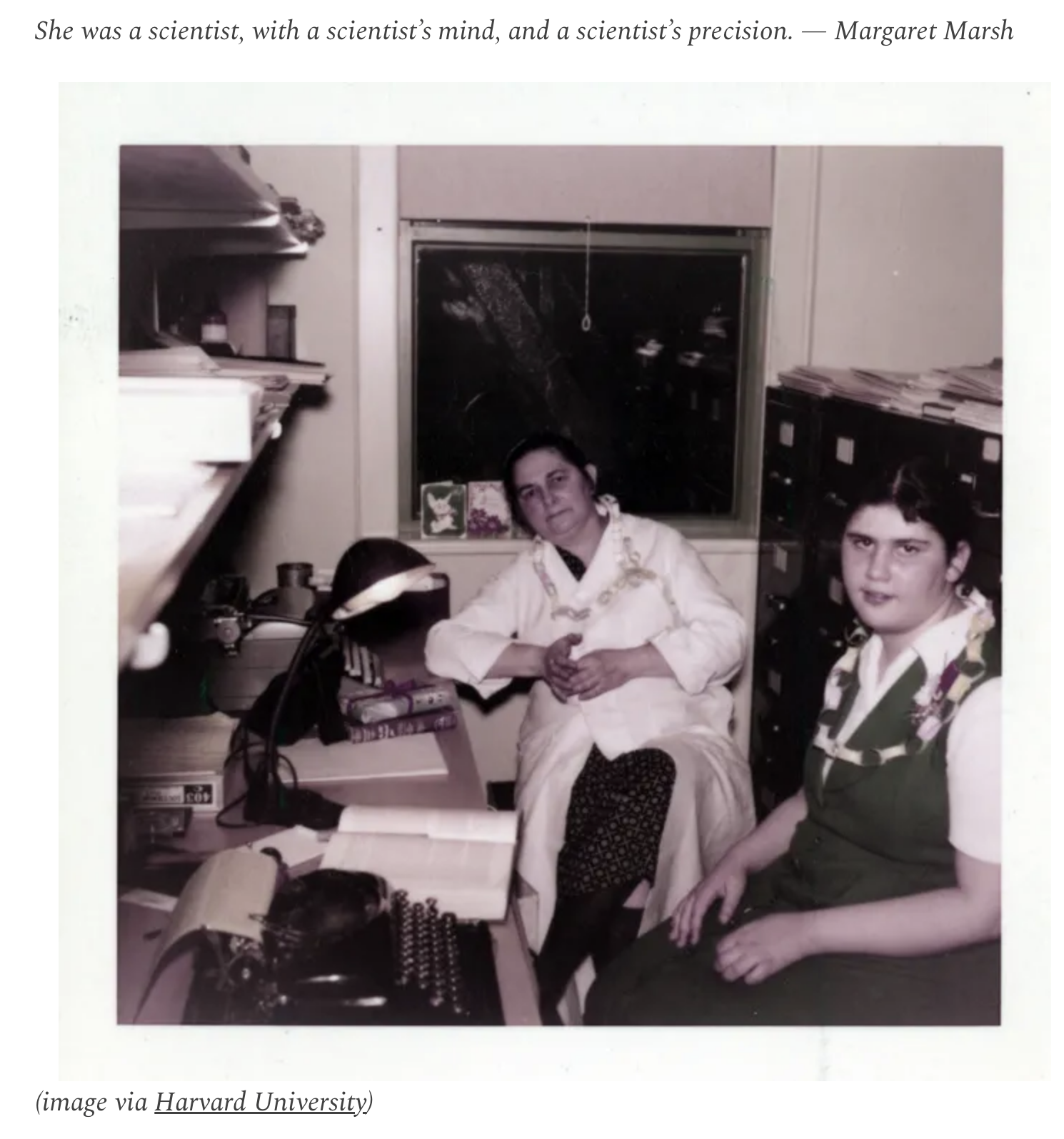 Miriam Menkin sitting next to lab bench with her daughter by her side.