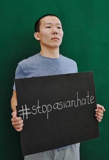 Asian man holding sign that says, "#stopasianhate"