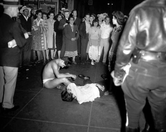A crowd of people looking at two men on the floor