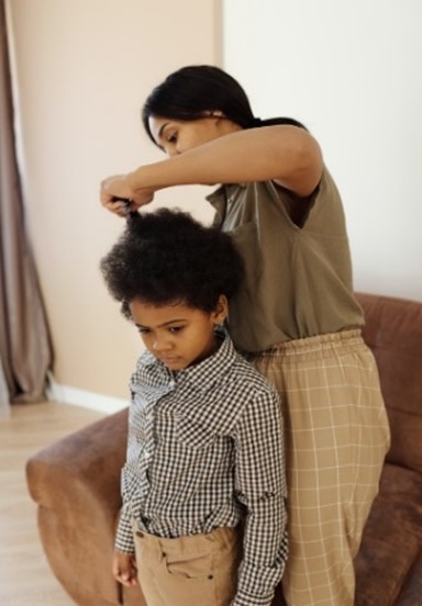 A woman combing a young boy's hair
