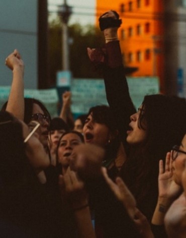 Group of unrecognizable people raising fists in protest