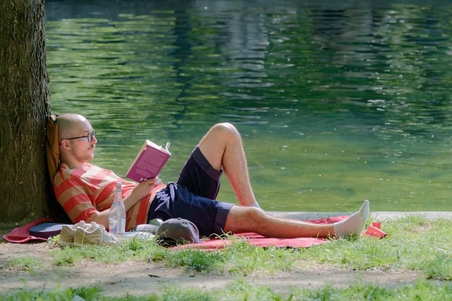 Man Reading Book by Lake