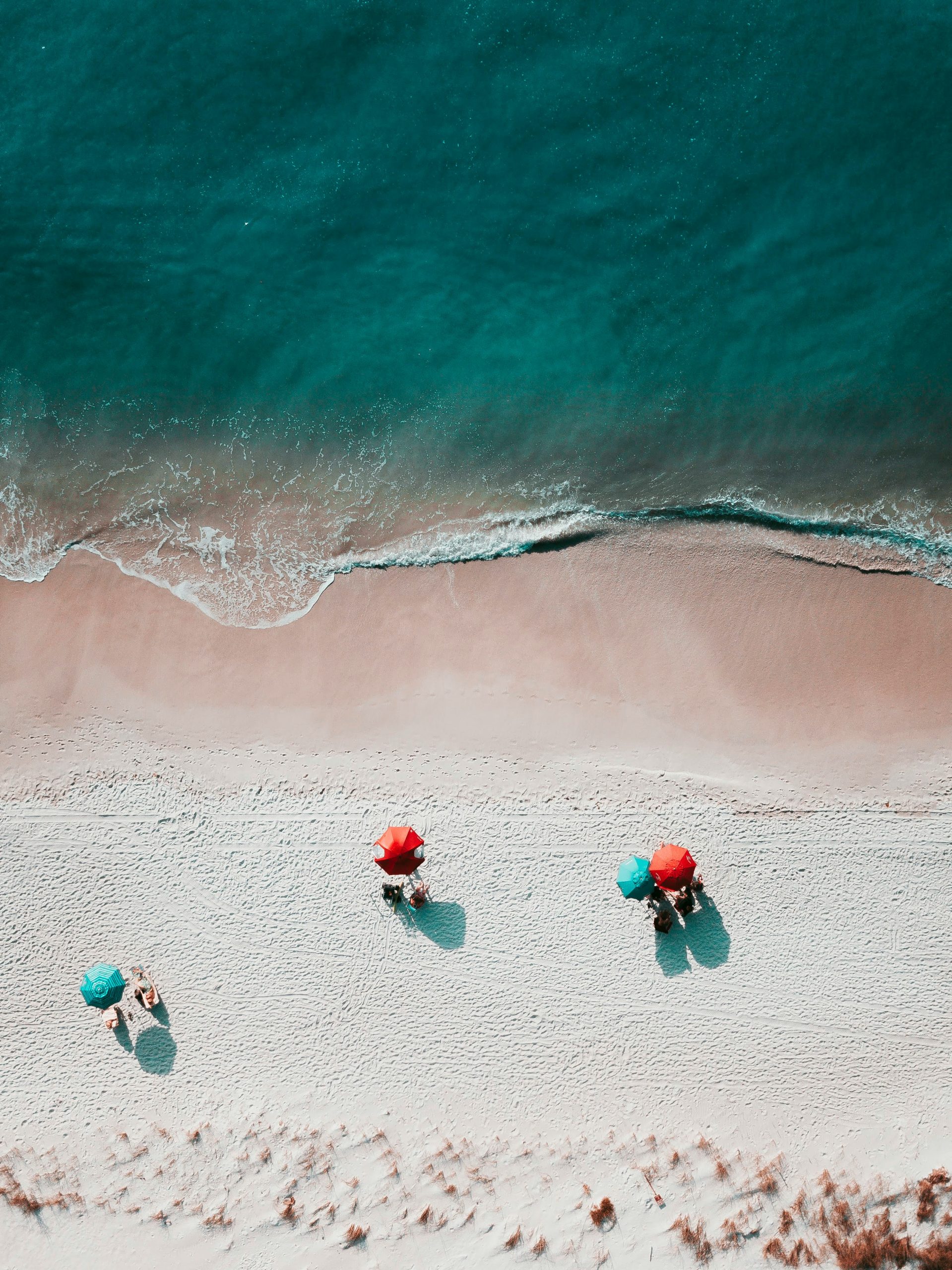 A photo of a beach with umbrellas and people