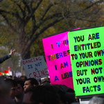 Protest sign states "You are entitled to your own opinions but not your own facts."