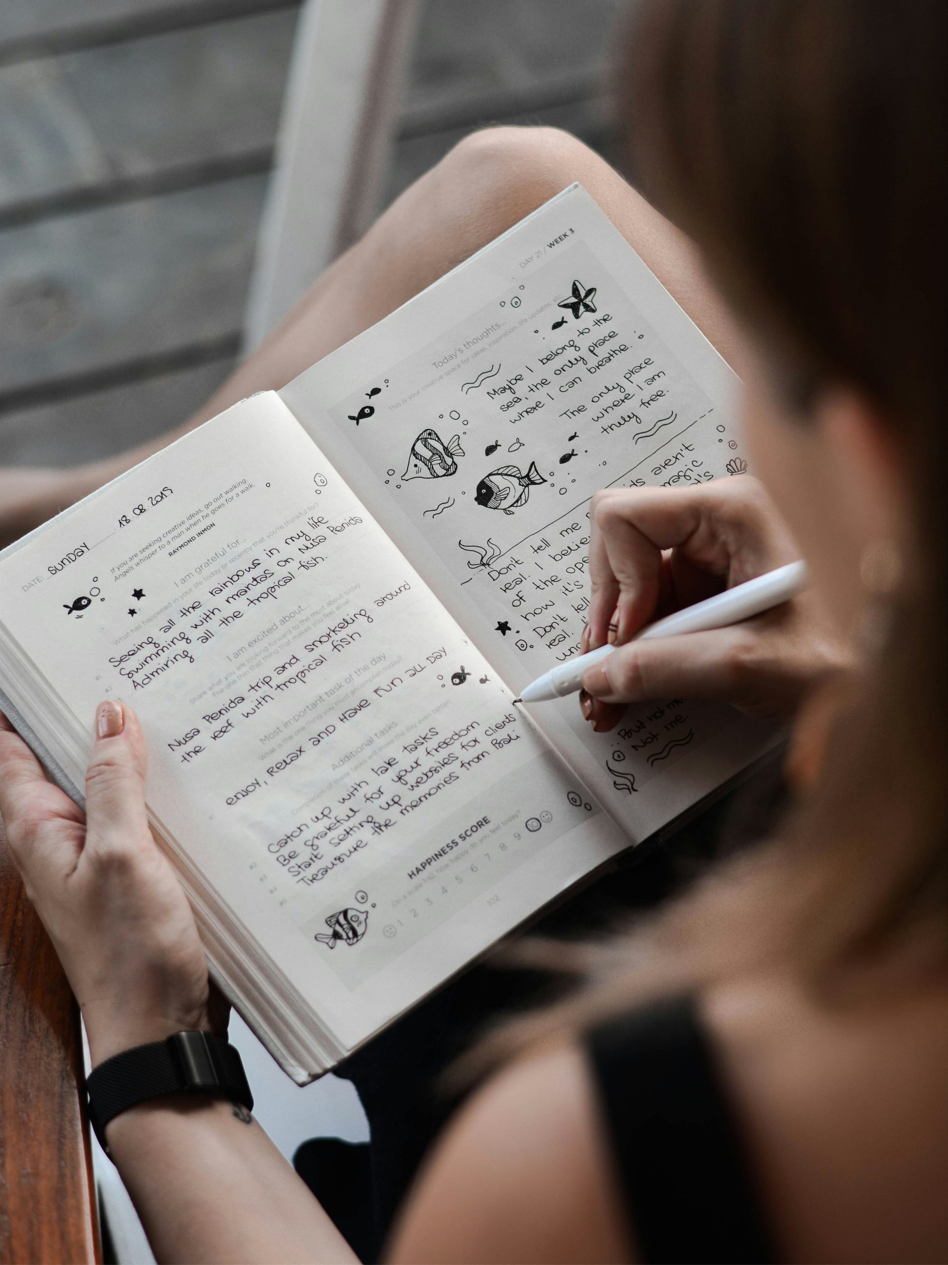 Image is of a person taking notes in a notebook