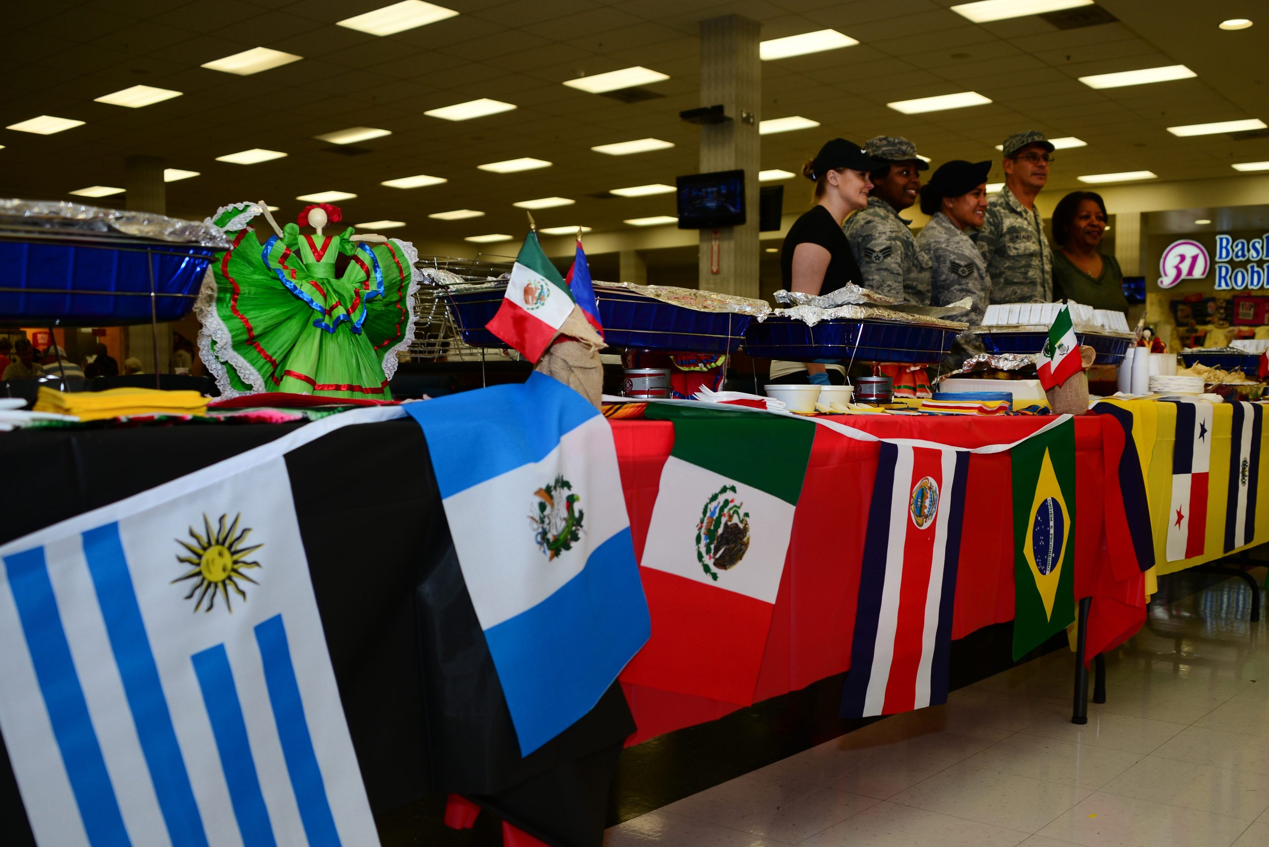 Flags of different Hispanic cultures hang on a table