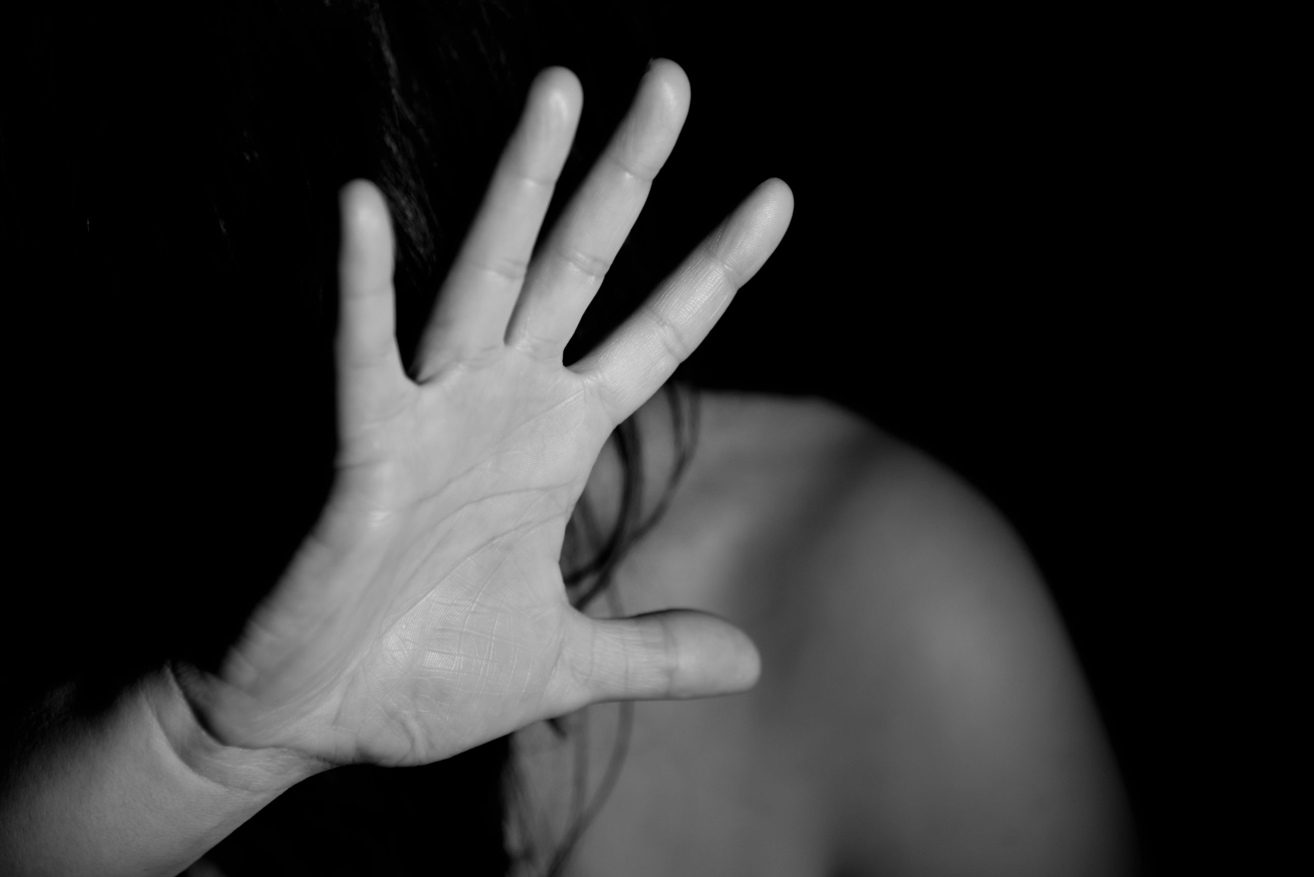 black and white photograph of a woman with her hand blocking her face