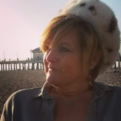 Picture of editor, Kimberly Bomar. She is sitting on the beach.