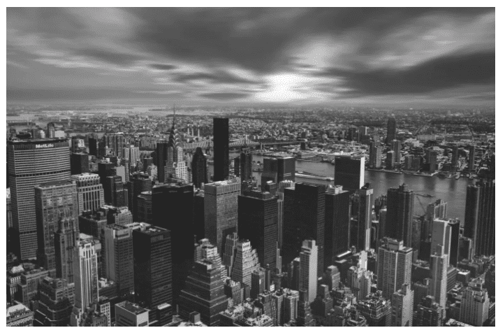 The result of adding CSS code to add a grayscale effect over the image of a high angle view of New York city's cityscape against the cloudy sky.