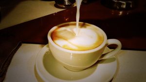 an image of milk being poured into coffee