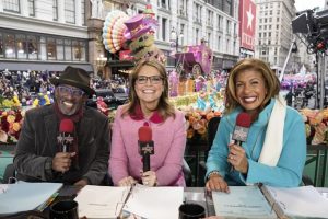 Hosts discussing a televised parade.