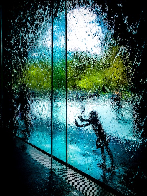 silhouette of child leaning into full-length picture window