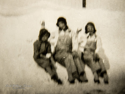 Ella and her two sisters sitting on a snow drift