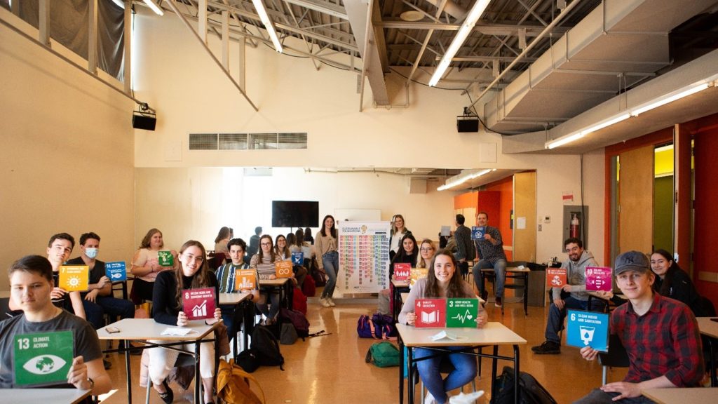 students in desks holding SDG cards