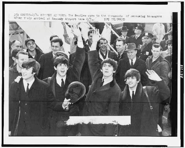 Black and white photo of young men waving