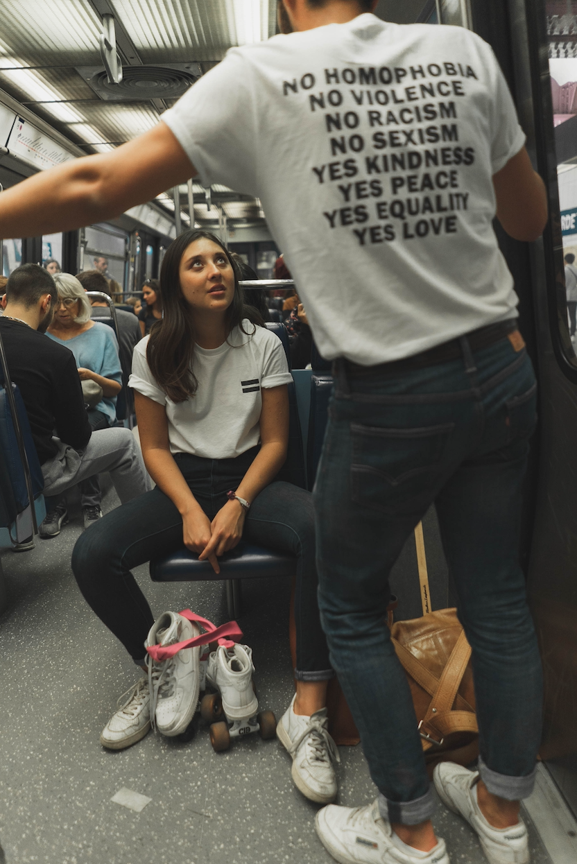 Man with social justice tee shirt talking to woman on train