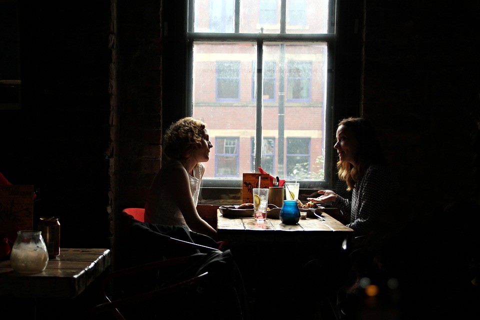 two people talking in a dark restaurant