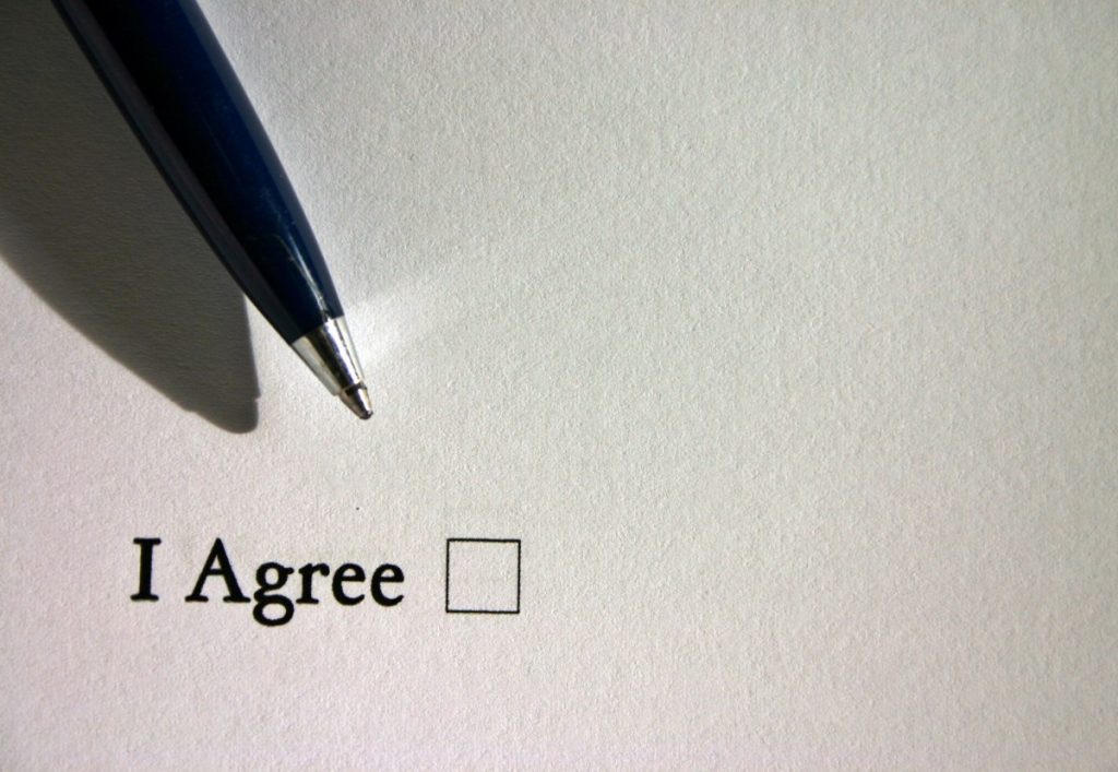 a paper has a checkbox that says "I agree" with a pen over it