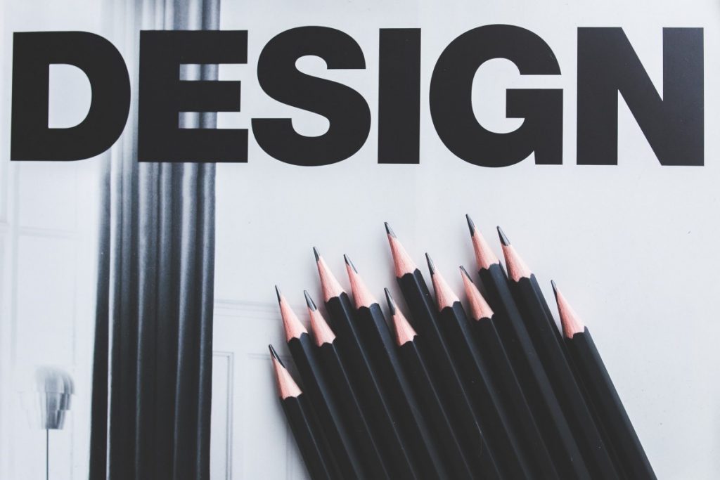 the word "design" in black letters with some sharpened pencils underneath