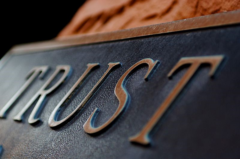 a metal sign with the word trust on it