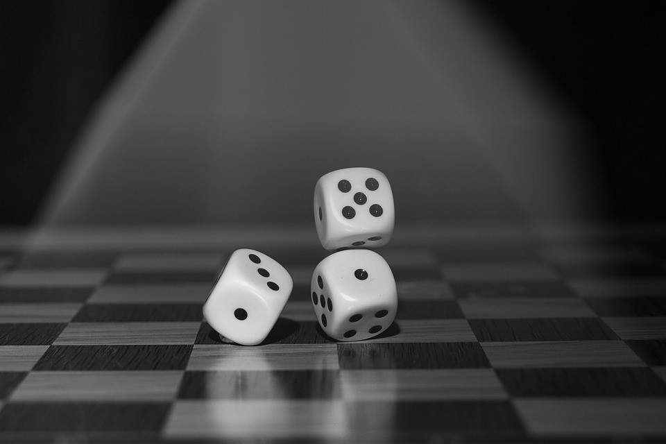 three dice hitting the ground under a spotlight