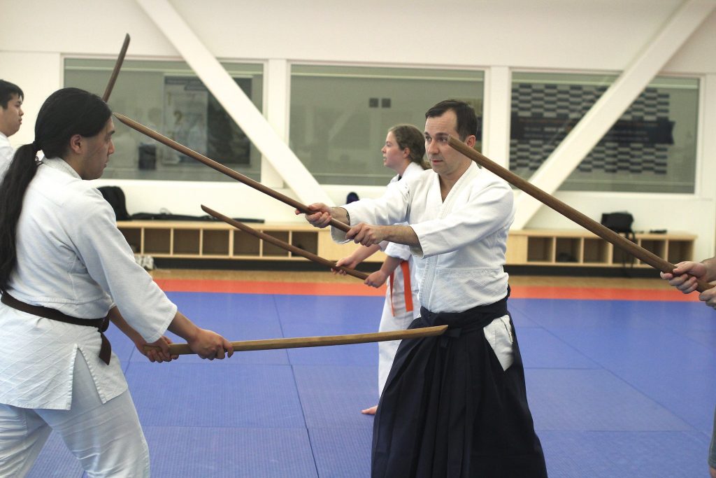 Students and an instructor practice aikido
